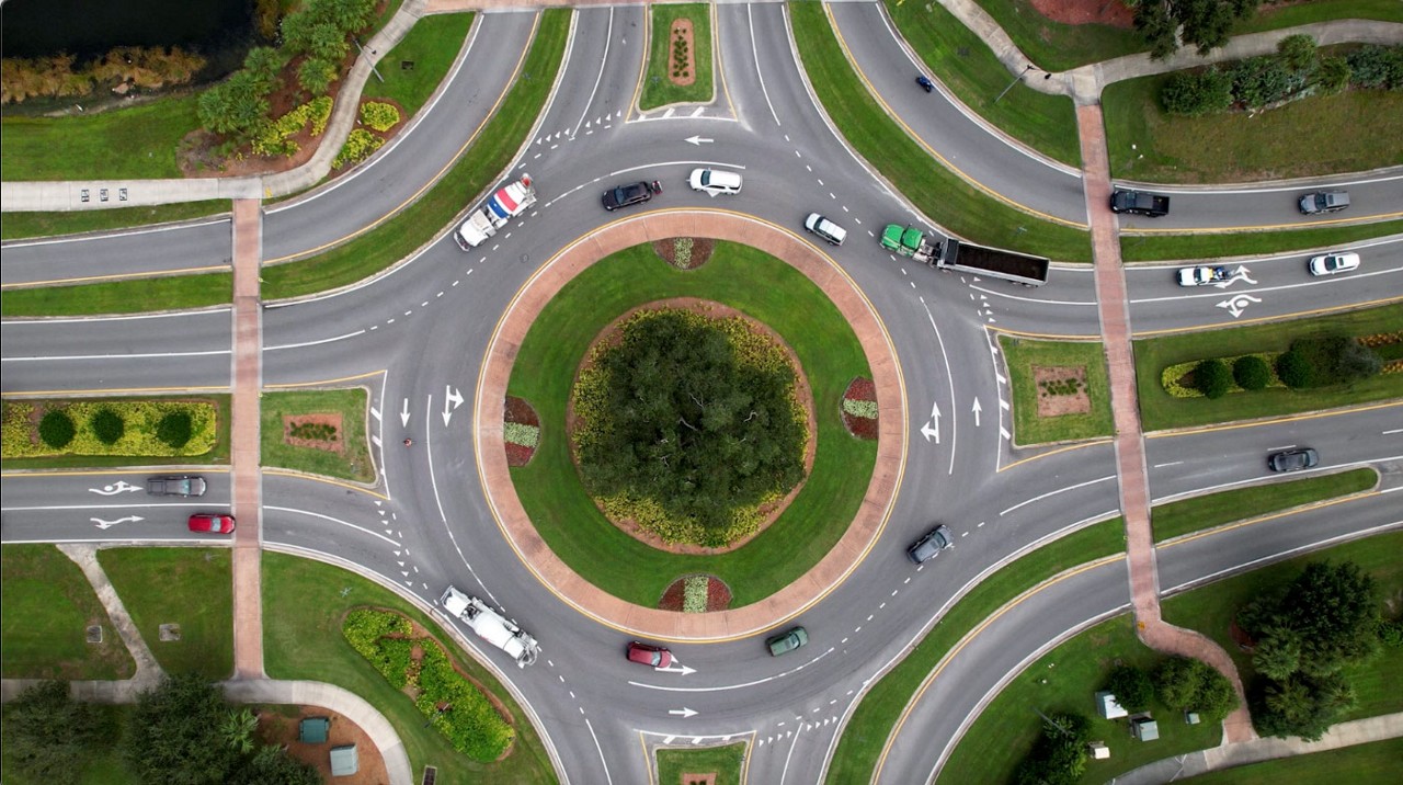 Aerial view of a traffic circle with cars entering and exiting.