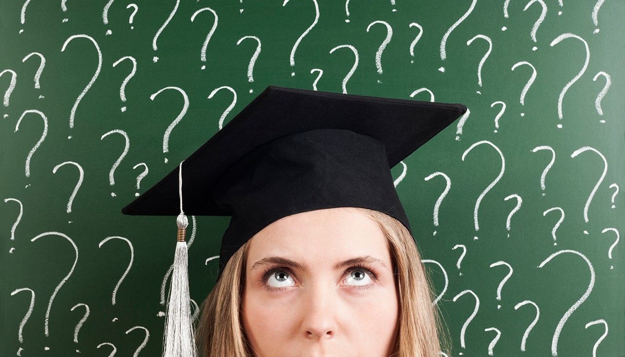 A woman with a graduation cap with a background of green with white questions marks all over it.