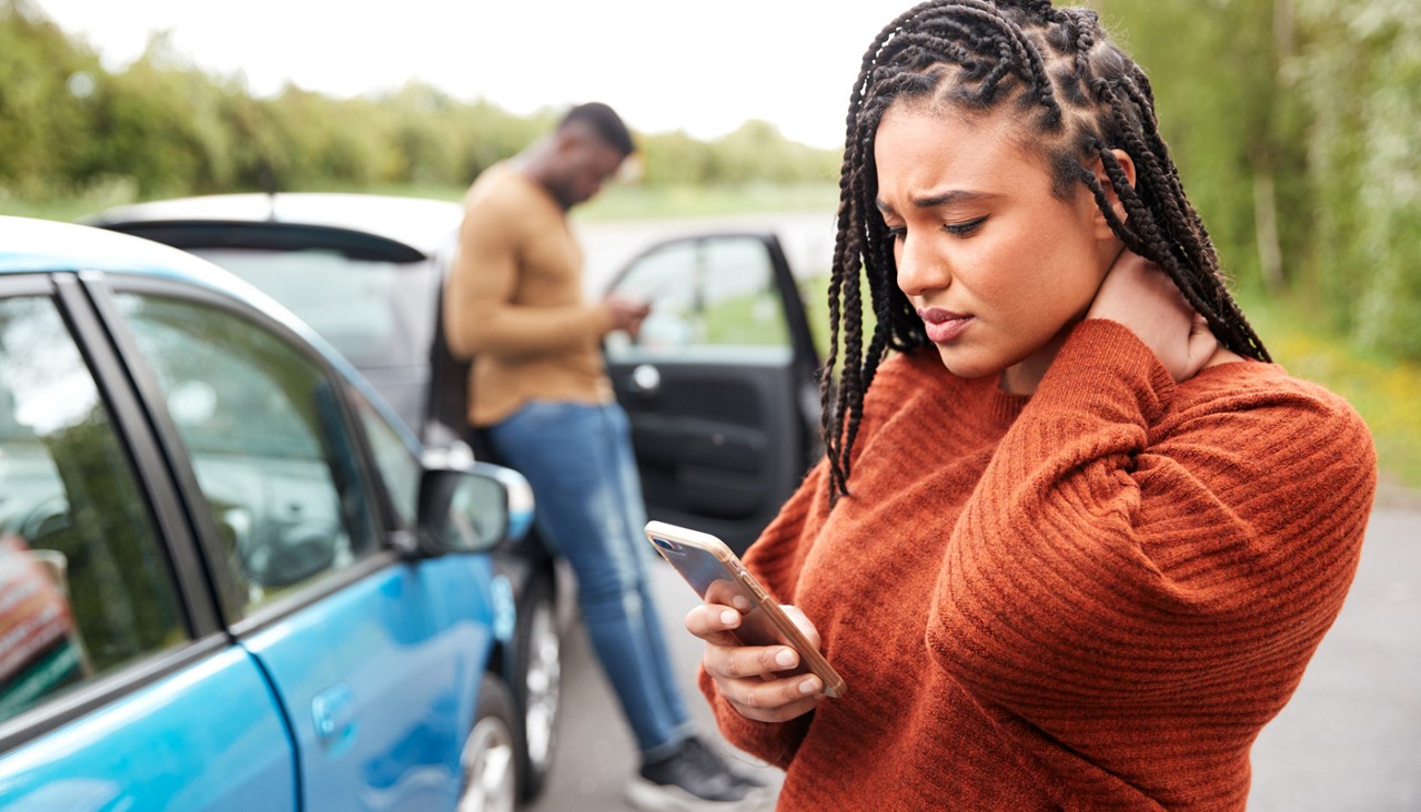 A woman in a crash calling her insurance company while the other driving calls his.