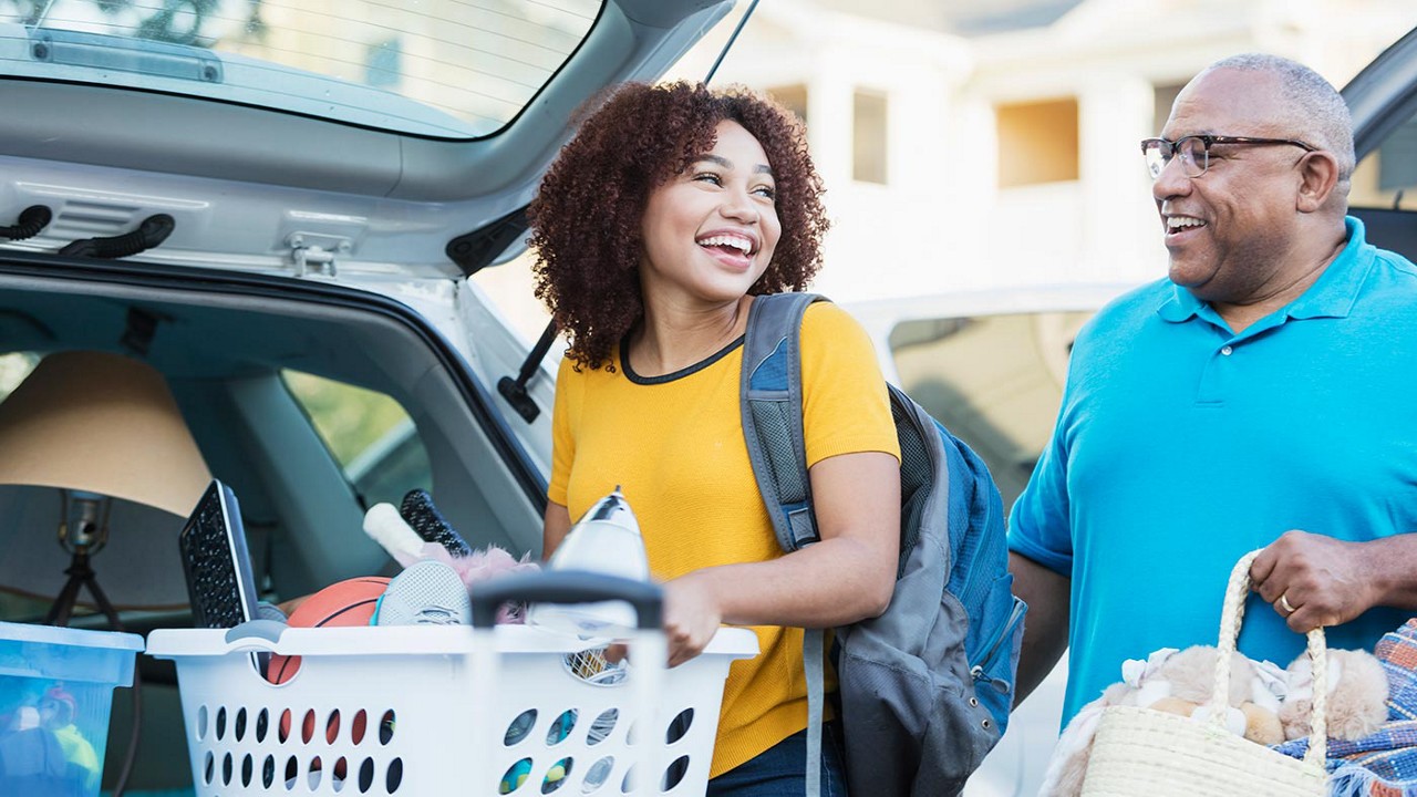 A father and daughter unloading a station wagon as she moves into a college dorm.