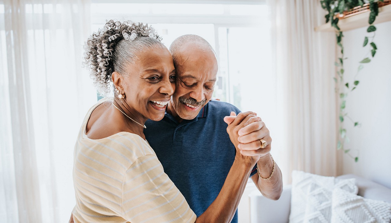 Couple smiling and dancing in their home