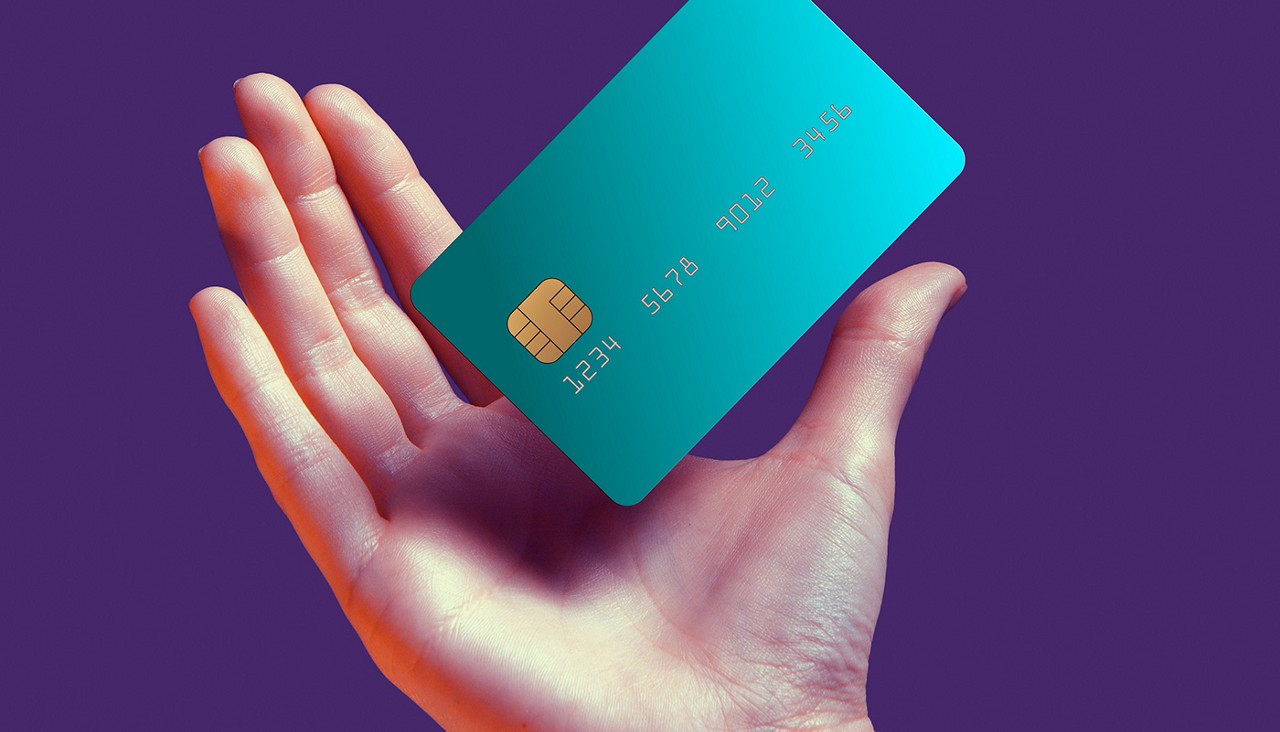Close up female hand holds levitating template mockup Bank credit card with online service isolated on violet background. High quality photo