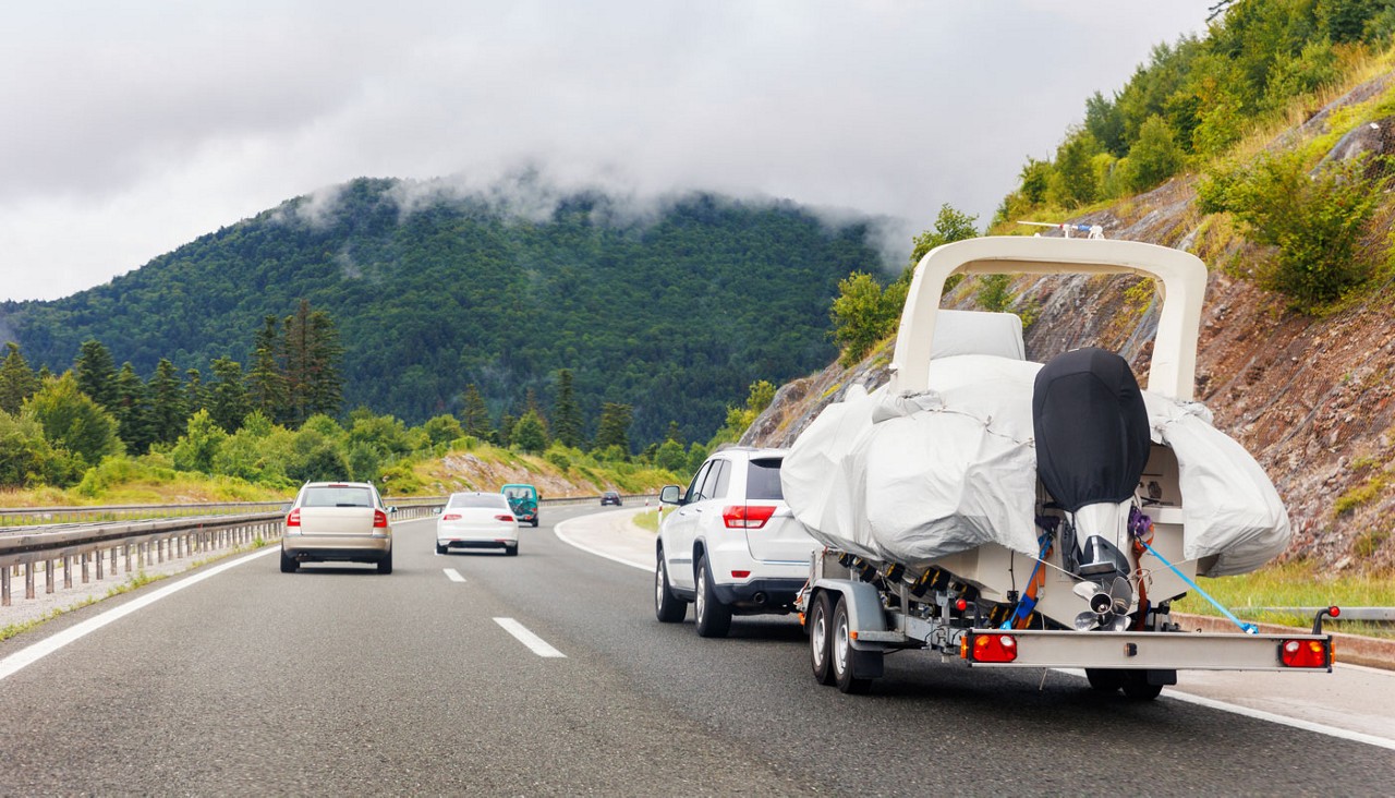 SUV towing boat on trailer on a mountain highway