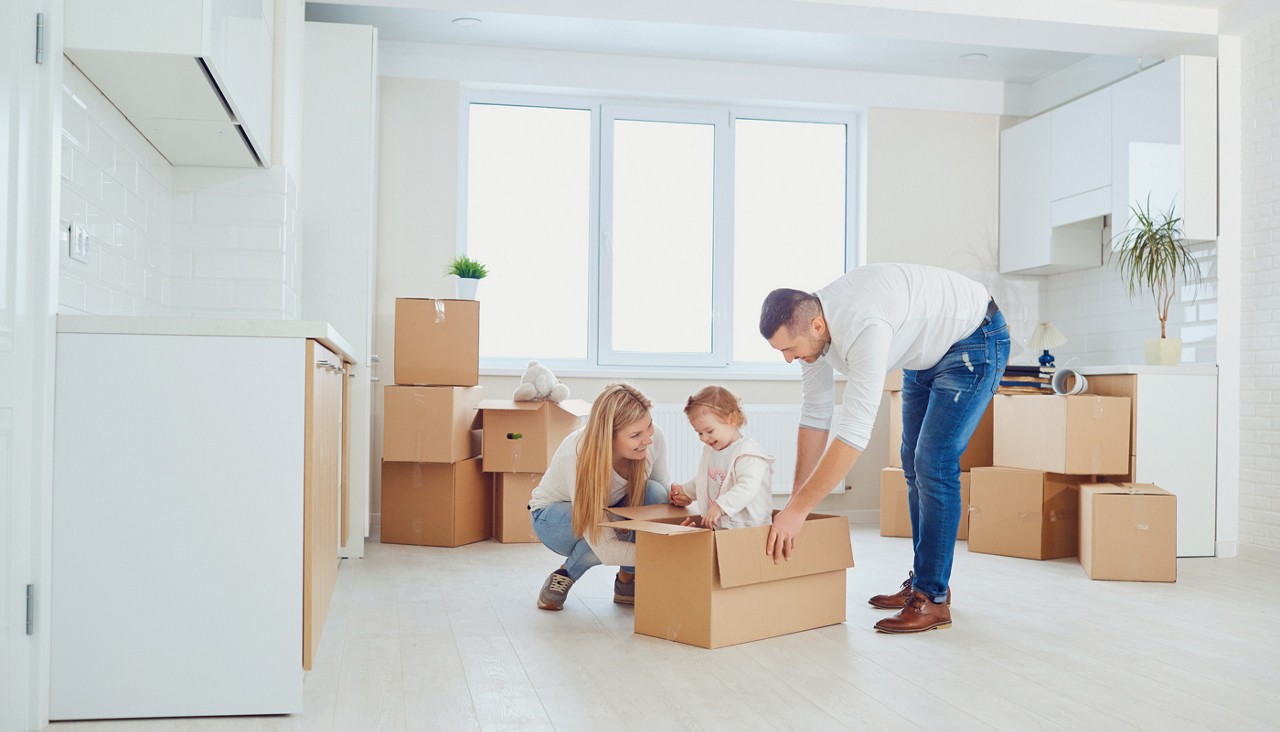Happy family unpacking boxes at new home