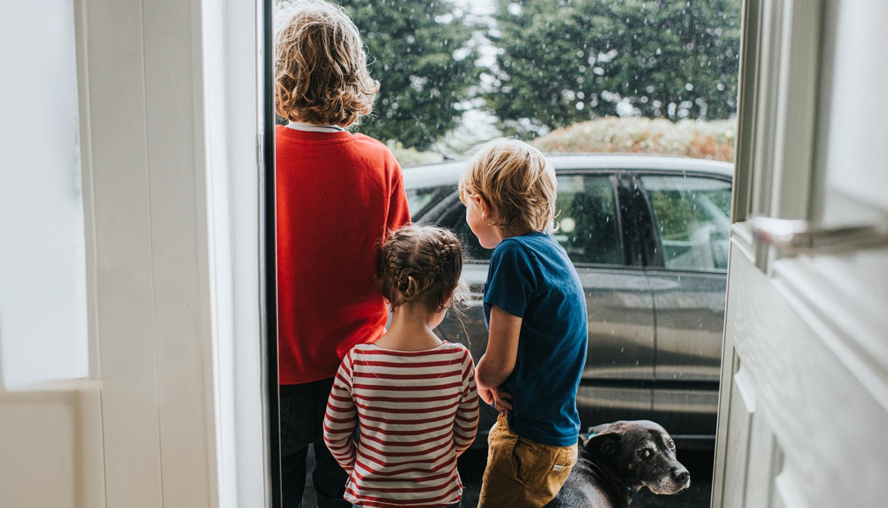 Three Kids and a Dog standing outside Front Door looking at Heavy Rain