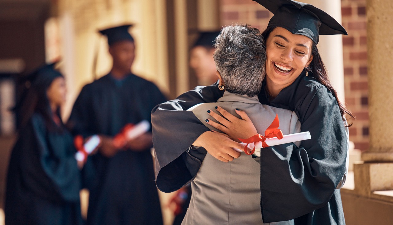 Graduate receives a hug from parent or family member after graduation.