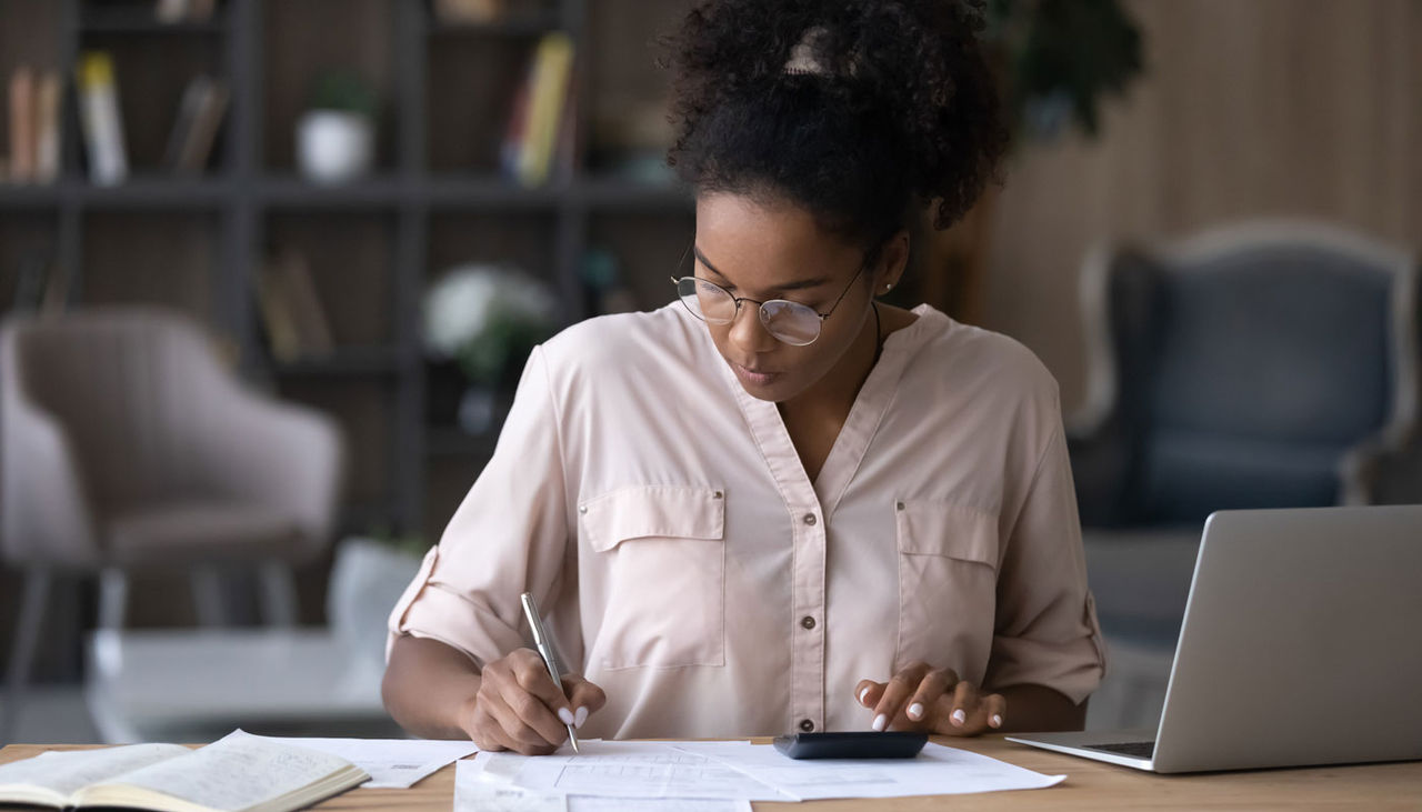 Woman calculating expenses using calculator