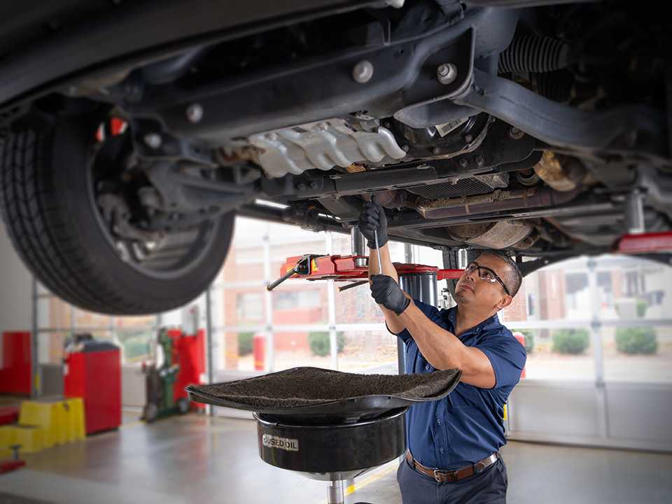 Technician checking the car oil.